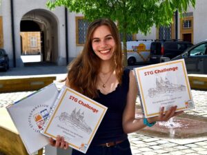 STG Challenge: Schülerin Lena Held mit den Spielpaketen vor dem Stiftsgymnasium St. Paul im Lavanttal.